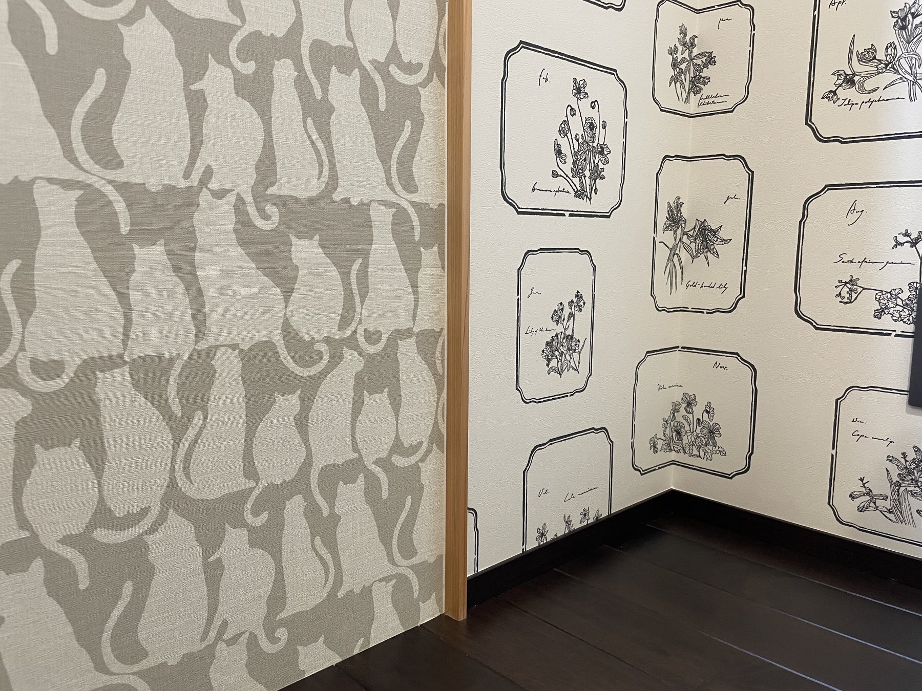白い木目調、猫柄、植物画の壁紙が交わる一角